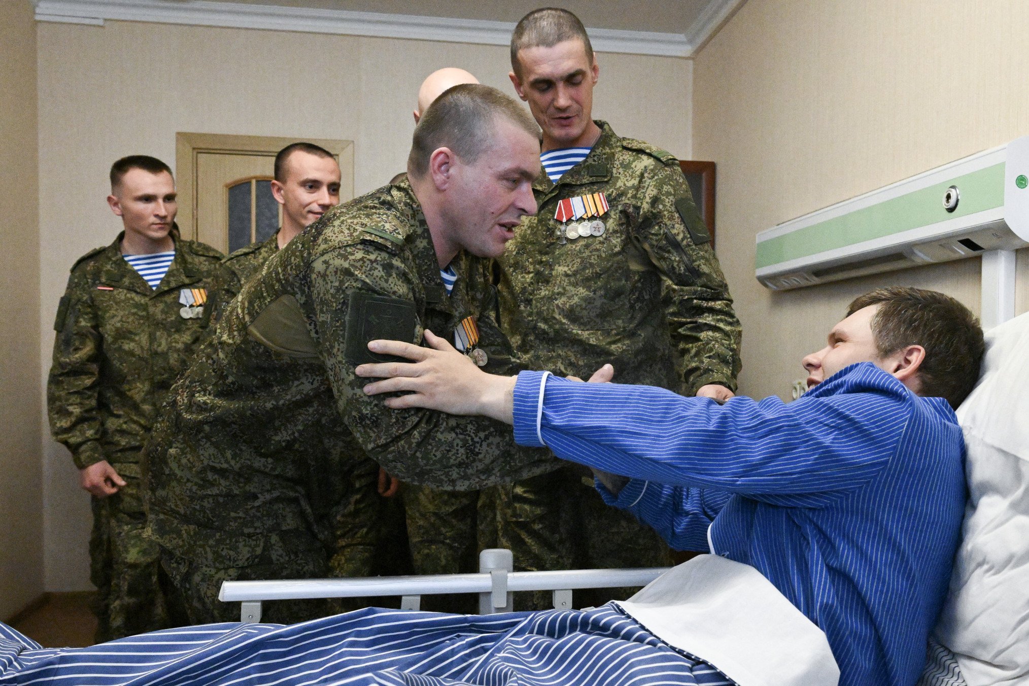 Раненого солдата чествуют за храбрость.